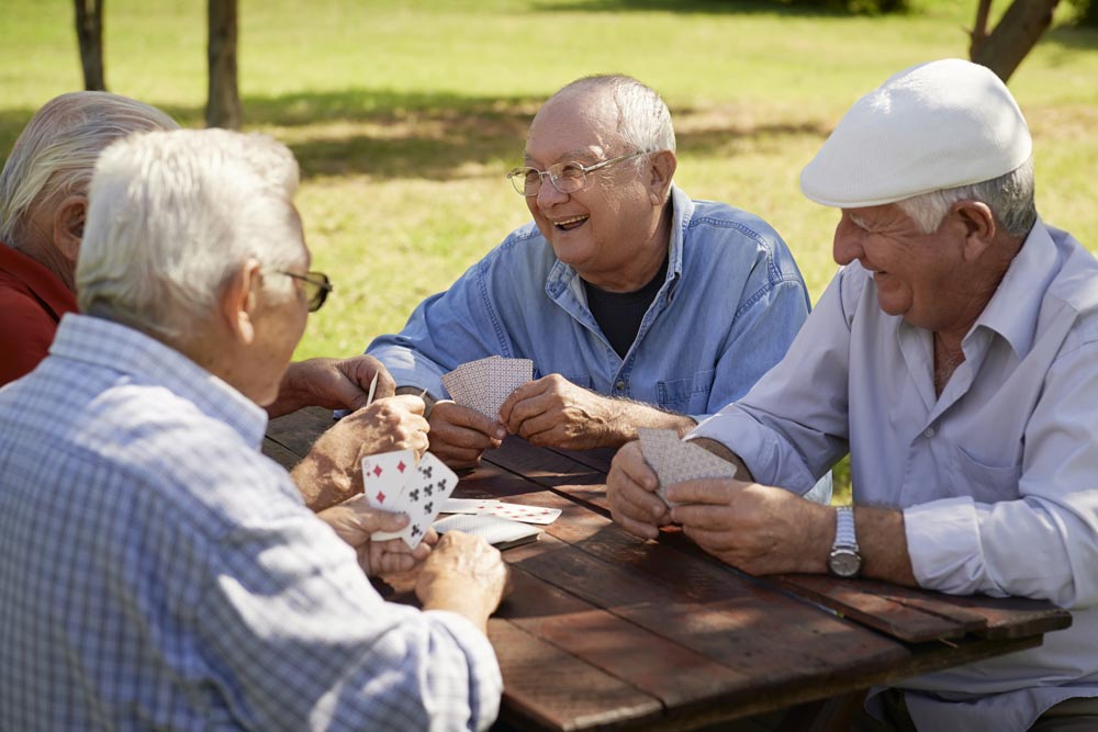 senior men playing card games in park